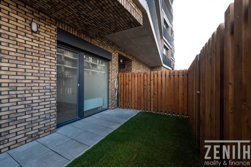 A terrace with paving and a lawn at a 1-room apartment in Bratislava - Petržalka.