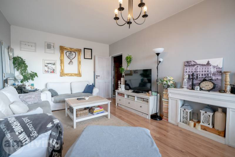 Living room in a 3-room apartment with white furniture and a floor with a wood decor.