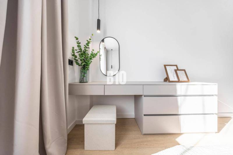 Interior detail of a 3-room apartment with a vanity table, mirror, and decorations.