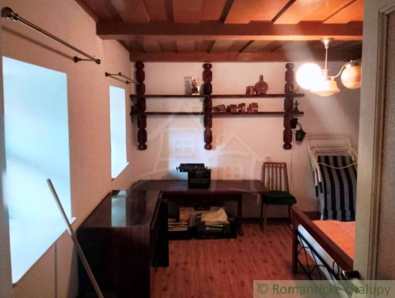 Interior of a cabin with a wood-patterned floor, a desk, and a chair.