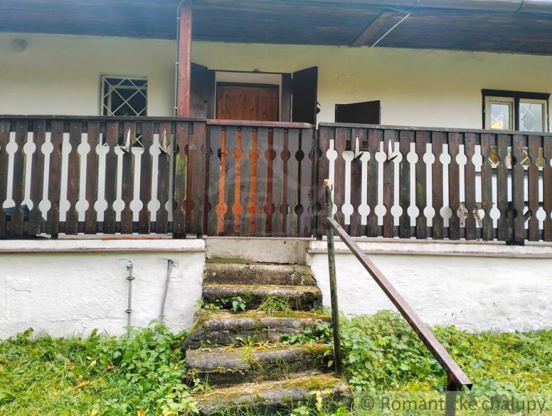 Stone steps leading to the cottage in Chocholná-Velčice with a wooden railing.