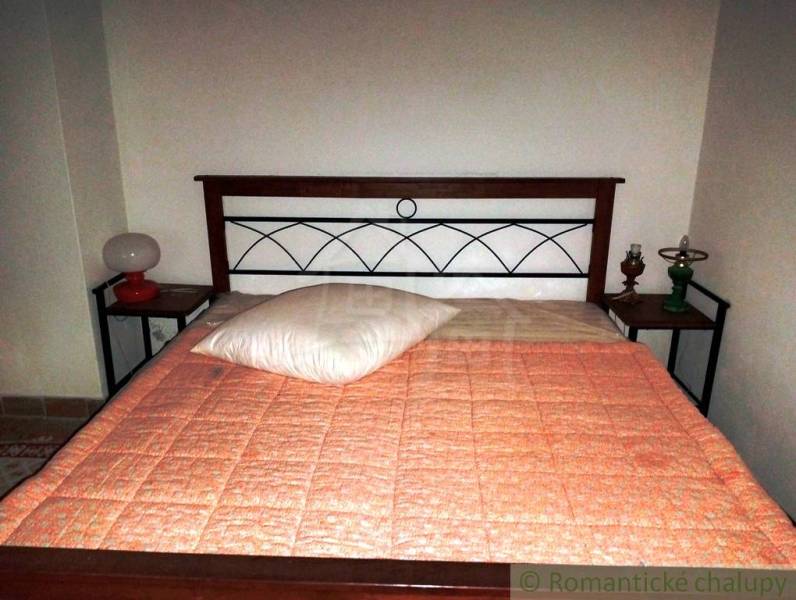 Simple bed in a cabin with a wooden headboard and lamps on the nightstands.