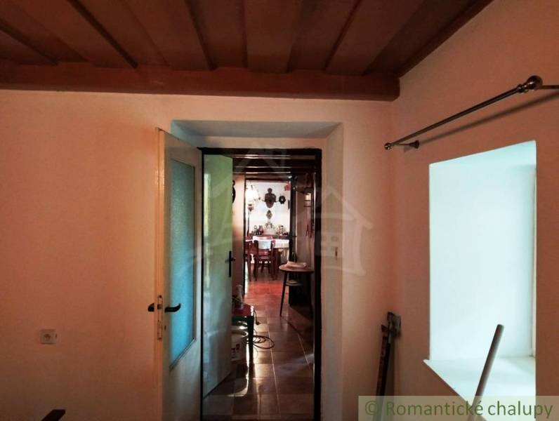 Interior of a cabin with access to another room; floor with wooden decor.