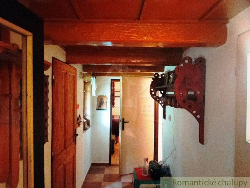 Interior of a cabin with wooden decor, decorative wall element, and doors.