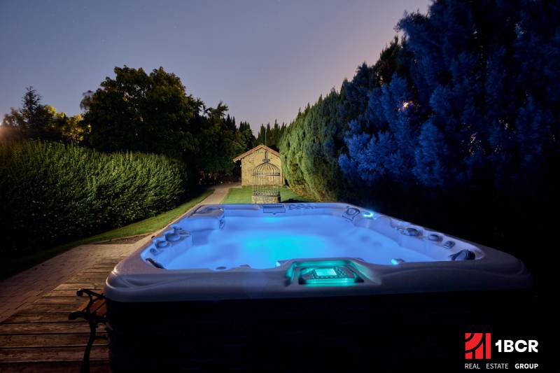 A nighttime hot tub in the yard of the Villa on Park Street in Hvezdoslavov, surrounded by trees.