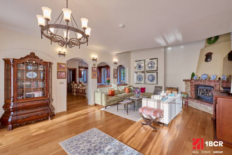 Living room in the villa with wood-patterned flooring and stylish lighting.