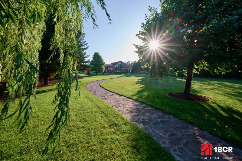 A stone pathway lined with trees in the garden of a villa on Parková Street in Hviezdoslavov.