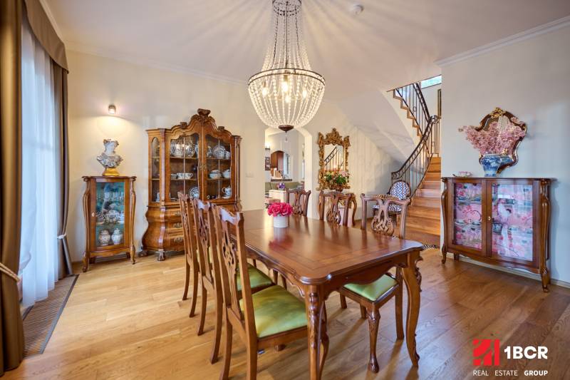 Dining room in the villa with stylish furniture and wooden decor flooring.