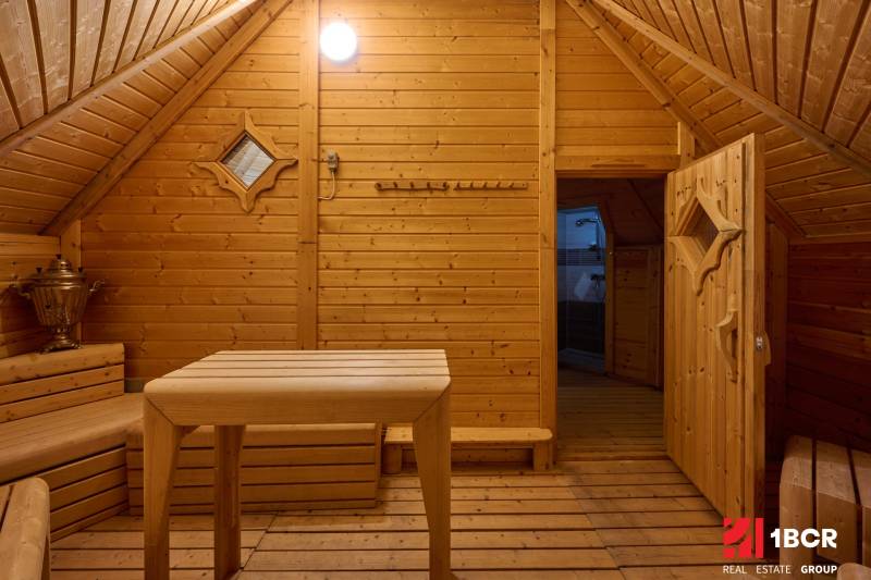 The interior of a villa with wooden decor, a table, and a bench, reminiscent of a sauna.