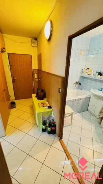 Hallway with bathroom entrance, tiled floor, 3-room apartment, wooden wall paneling.