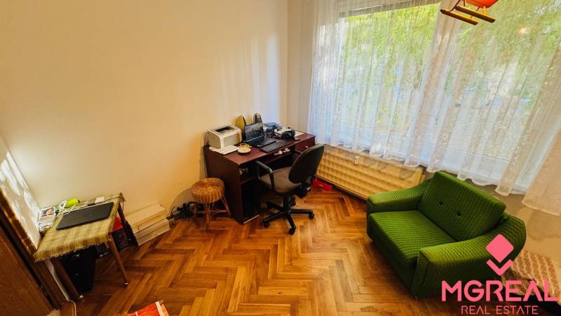 A room in a 3-room apartment with a desk and a floor with a wooden decor.