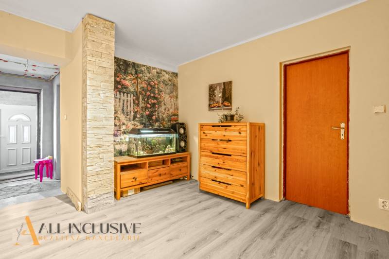 Family house with a wooden dresser, an aquarium, and a floor with a wooden decor.