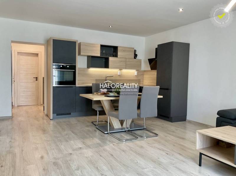A kitchen in a 3-room apartment with a kitchenette and a dining table, flooring with a wooden decor.