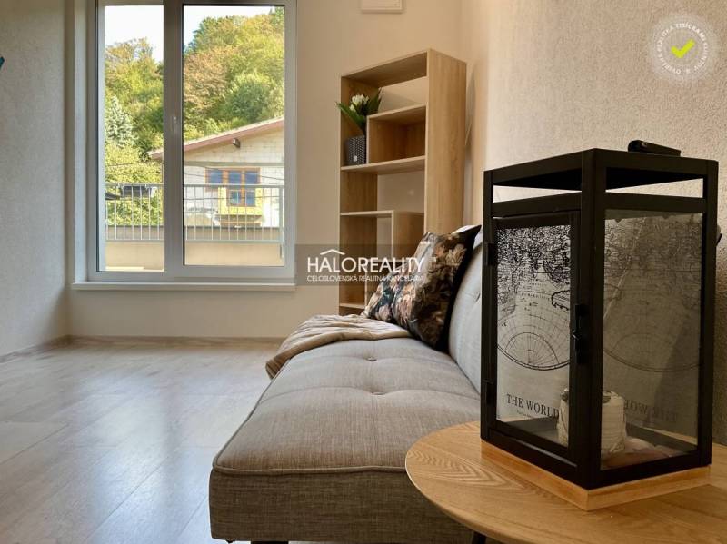 Living room in a 3-room apartment with a wood-patterned floor and a large window.