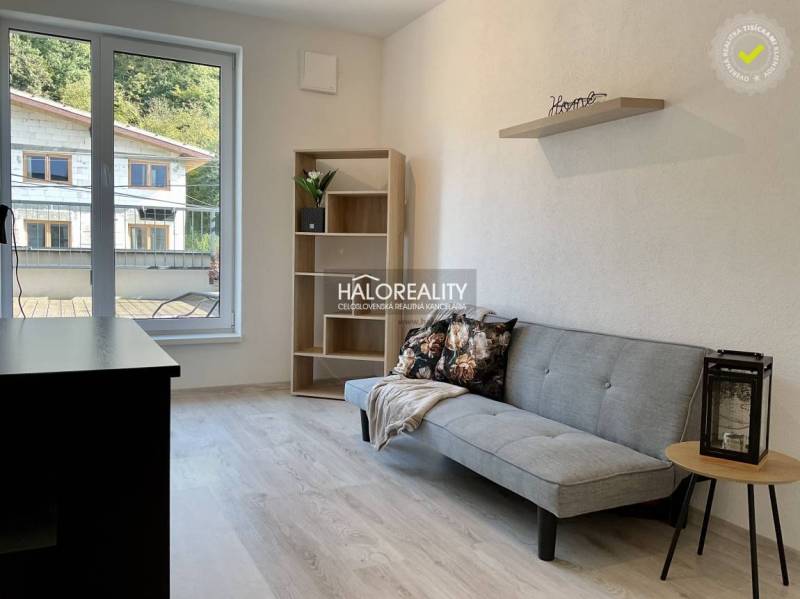 Living room in a three-room apartment with a wooden decor floor and large windows.