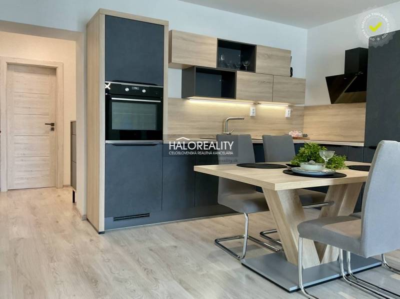 The kitchen of a 3-room apartment with a dining table, floor with wooden decor.