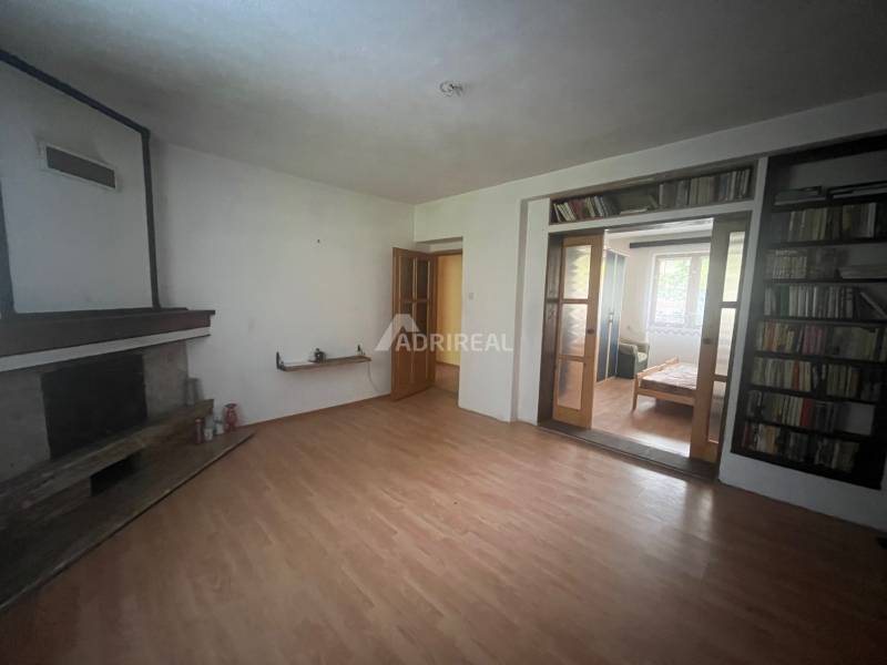Living room in a family house with a fireplace and a floor with a wooden decor.