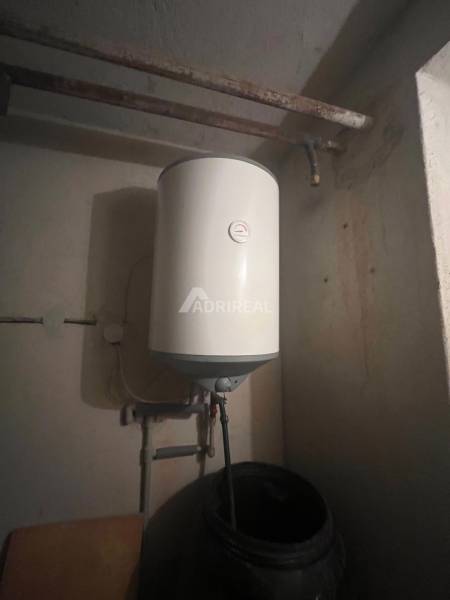 A boiler in a family house with a simple piping system and a dark environment.