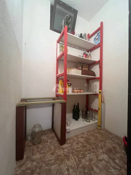 A pantry in a family house with a shelf for storing food and drinks.