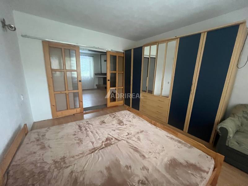 Bedroom in a family house with a bed, wardrobe, and sliding doors with glazing.