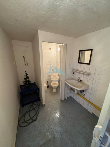 A bathroom in a family house with a toilet, sink, and tiled floor.