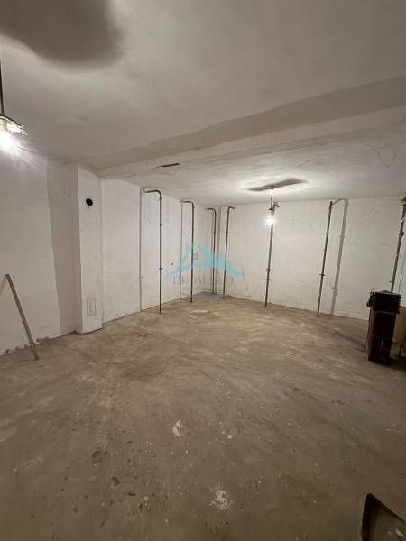 Empty room in a family house with a concrete floor and white walls.