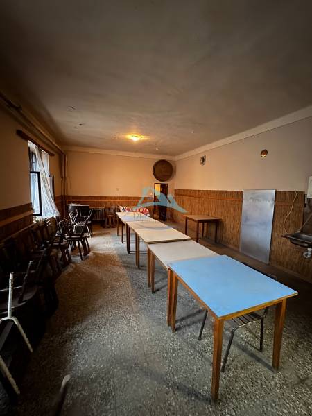 Dining room in a family house with wooden chairs and tables, pleasant lighting.