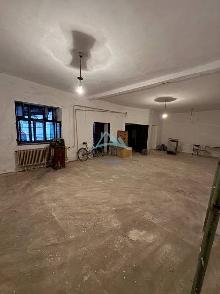 A spacious interior in a family house with a concrete floor, a window, and a bicycle.