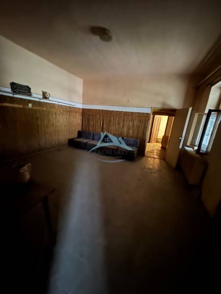 A dark room with a sofa and wooden paneling in a family house.