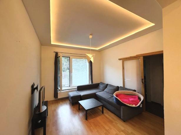 Living room in a family house with a corner sofa and a floor with a wooden decor.
