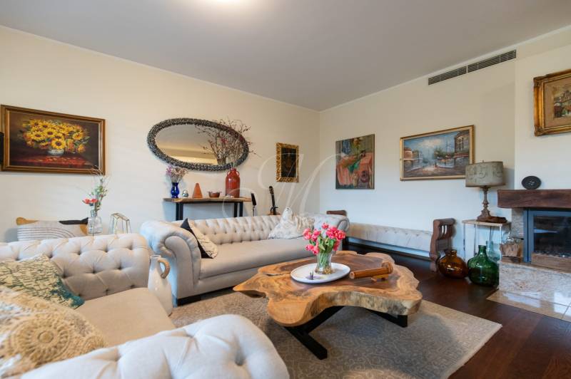 Living room in a 3-room apartment with comfortable seating, a fireplace, and a wooden decor floor.