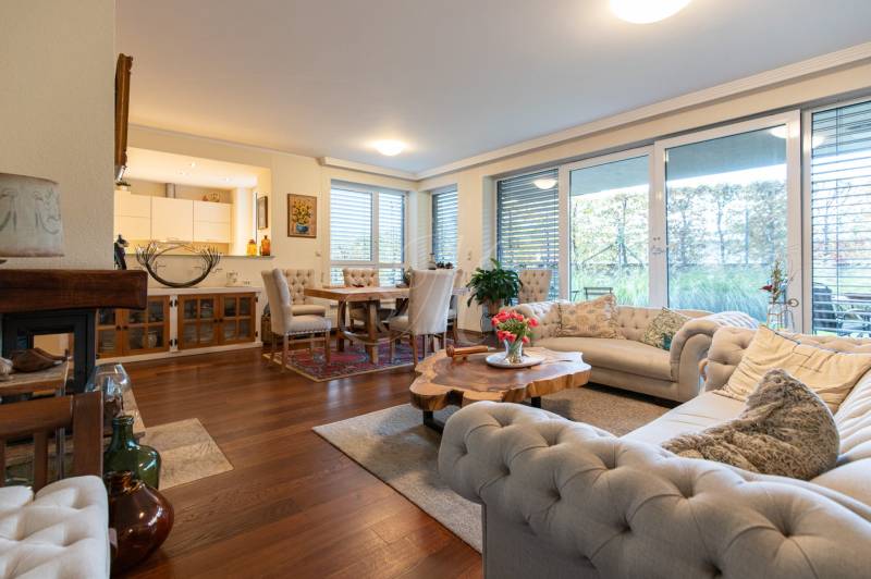 Living room in a 3-room apartment with a sofa, table, and wooden decor flooring.
