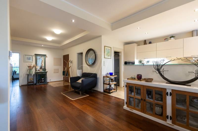 Living area of a 3-room apartment with a wooden decor floor and stylish furniture.