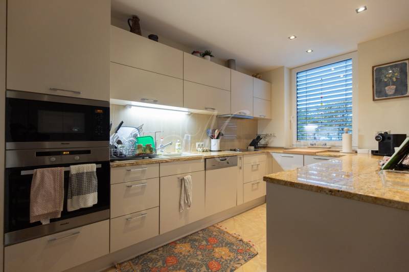 Corner kitchen unit in a 3-room apartment with built-in appliances and a large window.