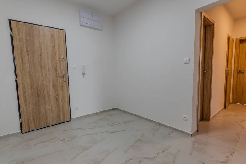 Hallway with tiles and doors in a 3-room apartment.