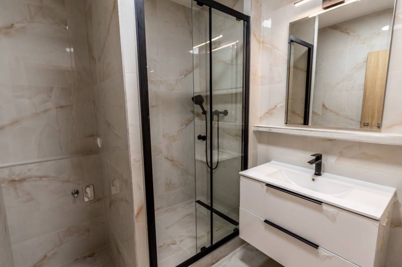 A bathroom with a shower and a sink in a 3-room apartment.