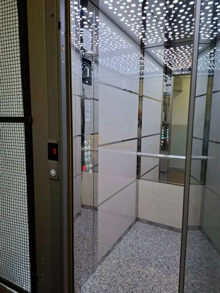 Elevator with modern design and mirrored panels, buttons and display.