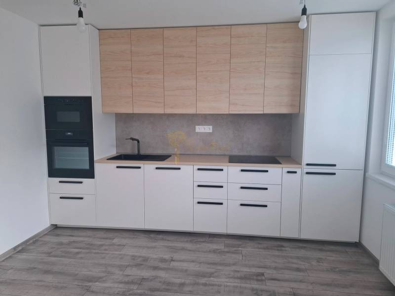 A kitchen in a 3-room apartment with a wooden decor floor and built-in appliances.