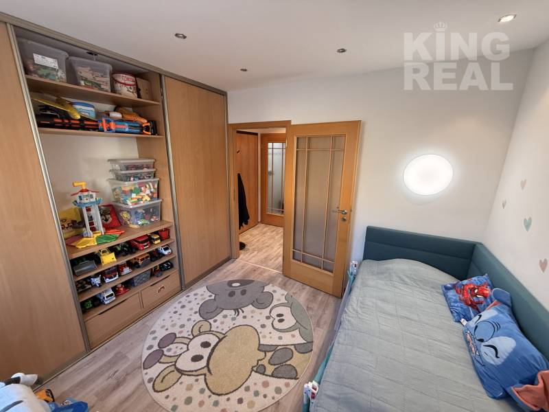 Children's room in a 3-room apartment with toys, storage spaces, and a floor with a wooden decor.