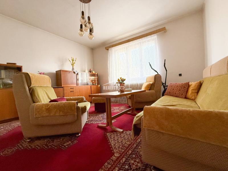 Living room in a family house with a sofa set, carpet, and wooden furniture.
