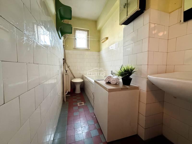 A bathroom in a family house with a sink, bathtub, toilet, and tiled floor.