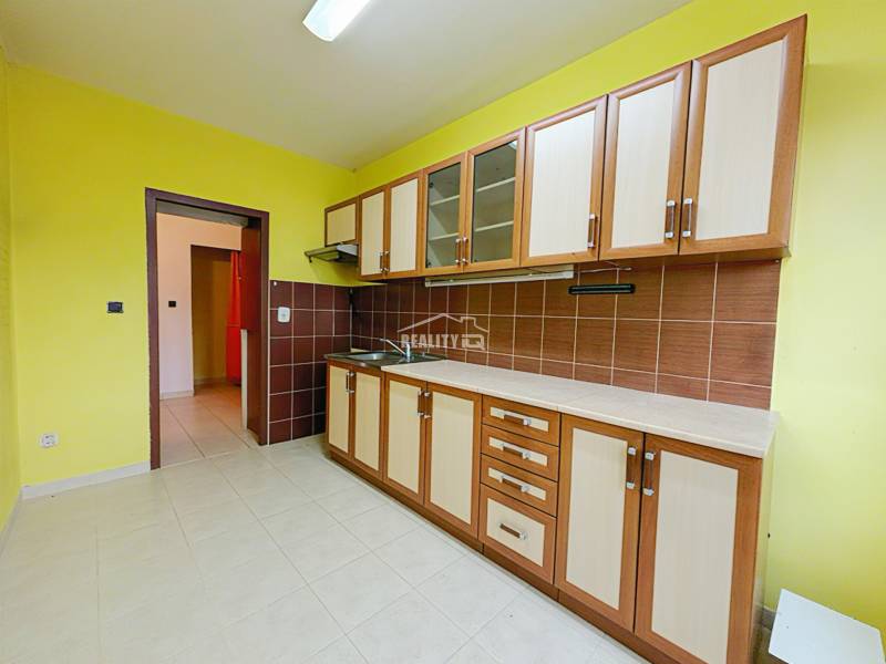 A kitchen unit with tiles and yellow walls in a 3-room apartment.