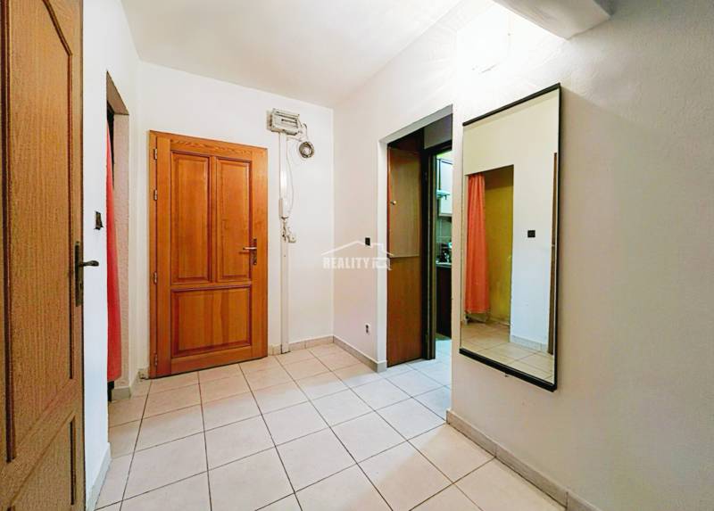 A bright hallway in a 3-room apartment with tiles and a large mirror.