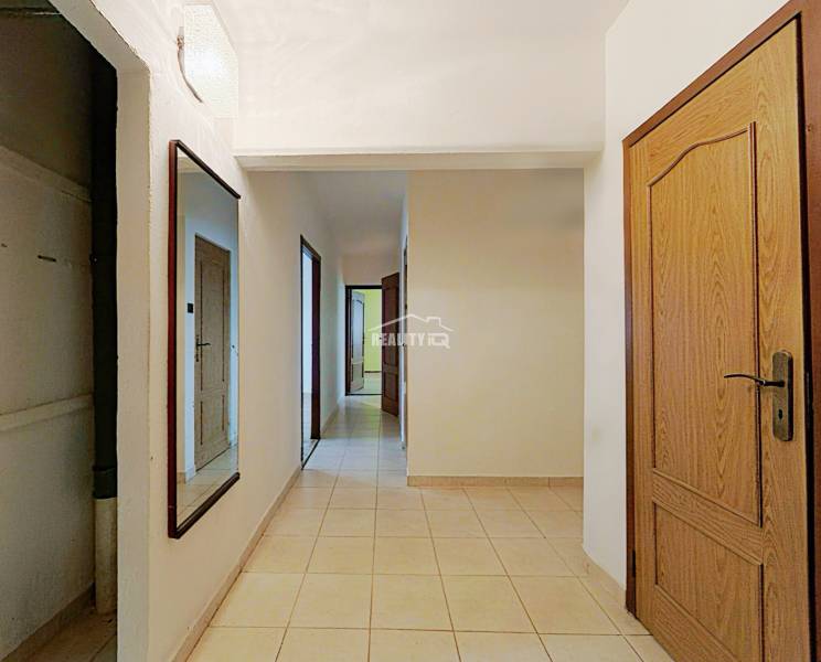 Tiled floor, wooden door, and mirror in a 3-room apartment.
