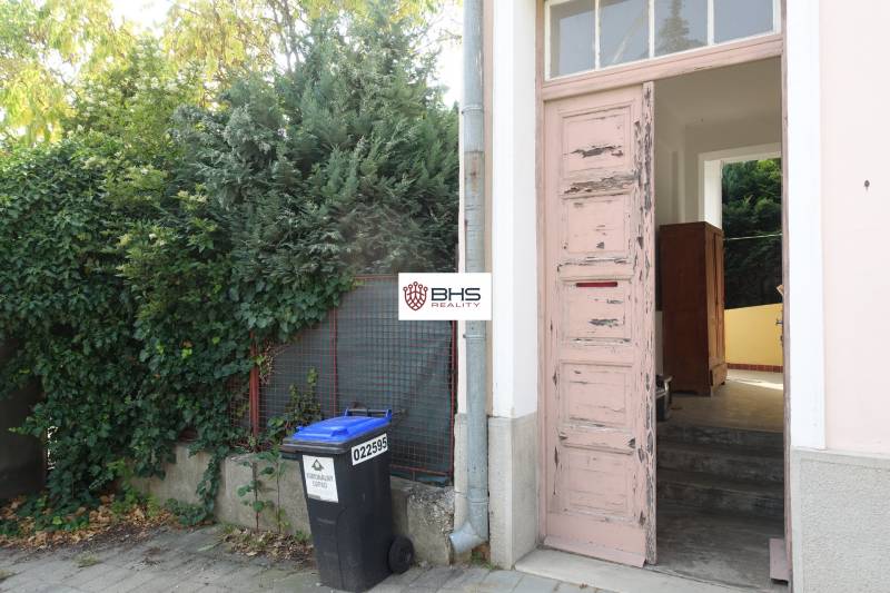 An old wooden gate to a family house on Hviezdoslavova Street in Piešťany surrounded by greenery.