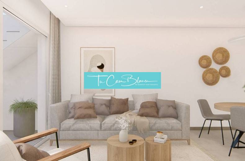 A bright living room in a holiday apartment with a gray sofa and a wooden coffee table.