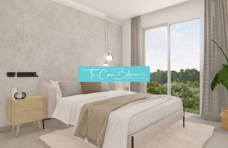 A bedroom in a holiday apartment with a large window, a plant, and a comfortable bed.