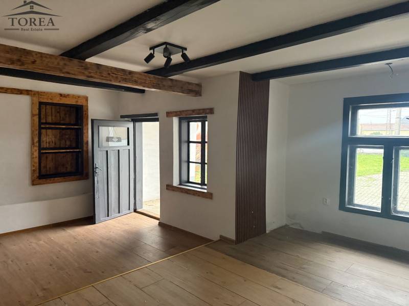 Interior of commercial spaces with a wooden beam ceiling and a floor with a wooden decor.
