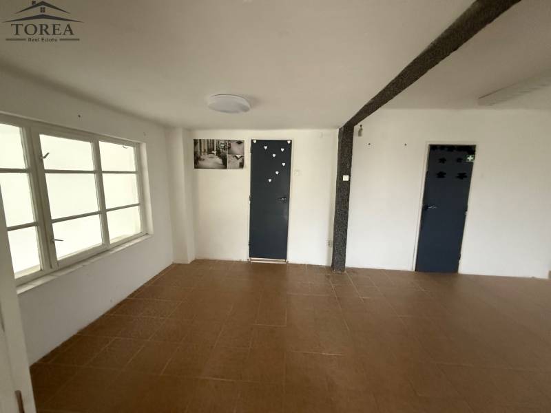 Commercial space with wood-patterned flooring, white walls, and a window.