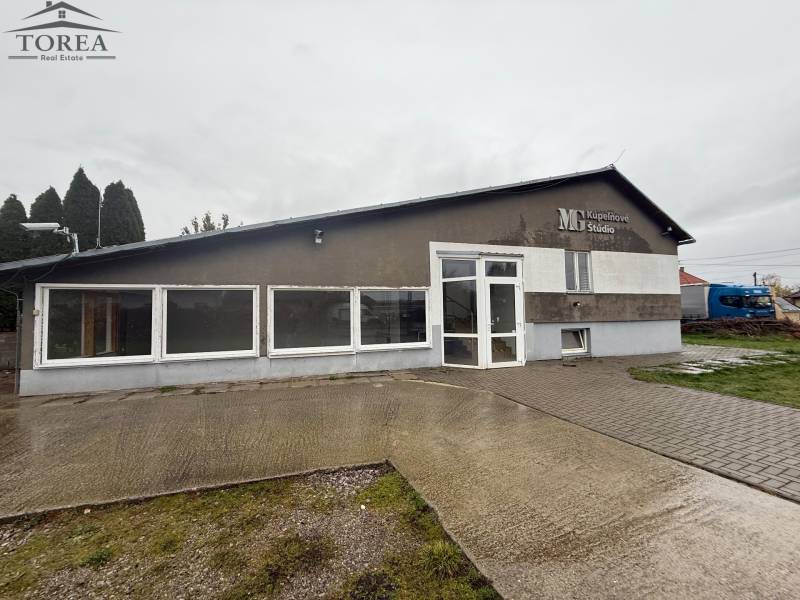 Commercial premises on Dolné Chlebany Street in Dolné Chlebany, with large windows and a paved area.